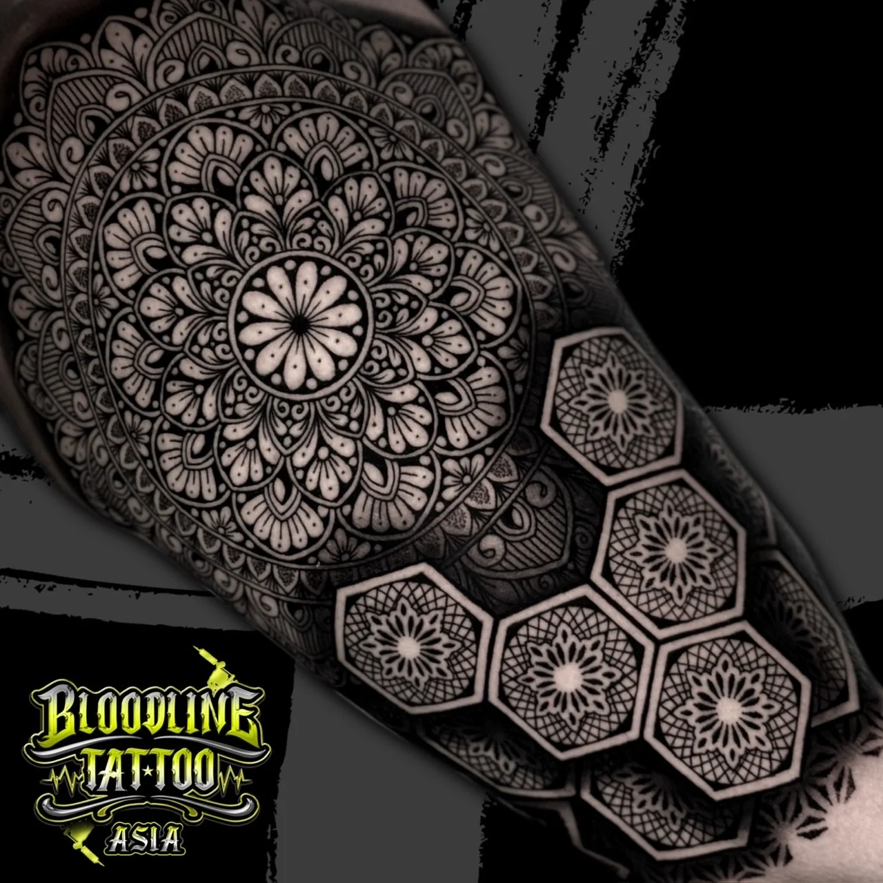 Shoulder mandala flowing into a honeycomb hex grid, each cell with a miniature geometric star in fine dotwork, at Bloodline Tattoo Bangkok.