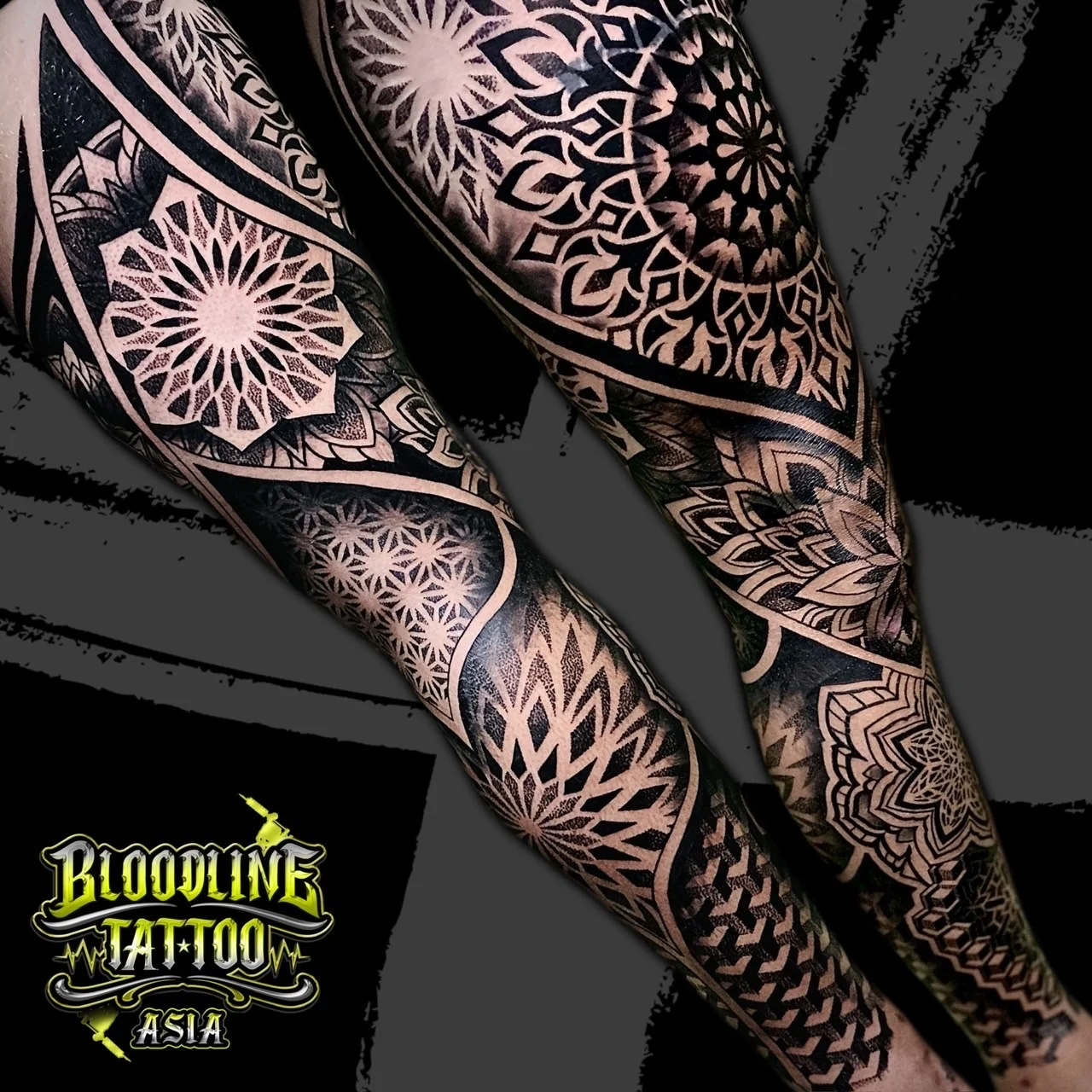 Full-leg sleeve with large geometric mandalas framed by bold blackwork curves and stippled dotwork gradients, at Bloodline Tattoo Bangkok.